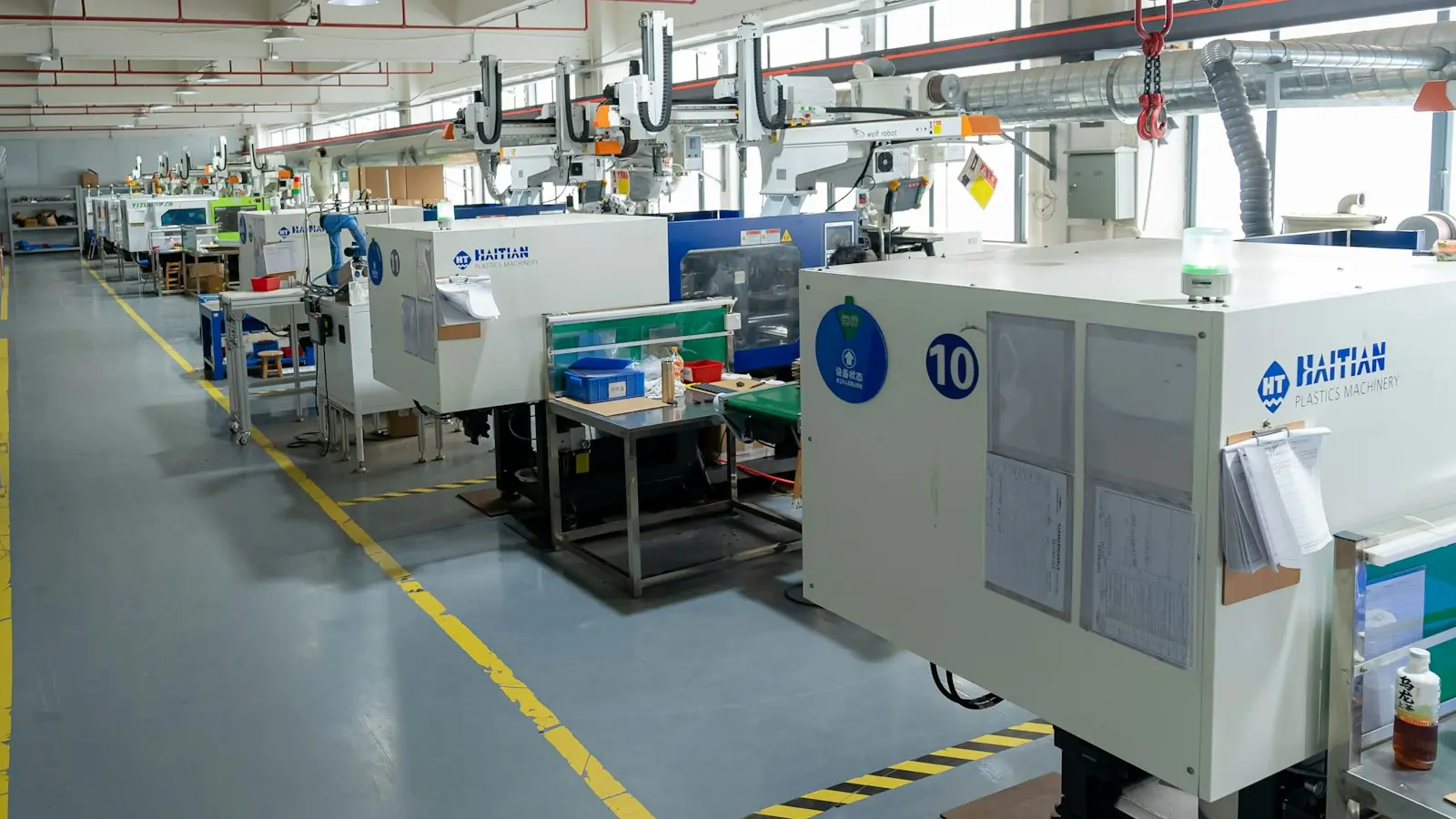 Row of injection moulding machines on a plant floor