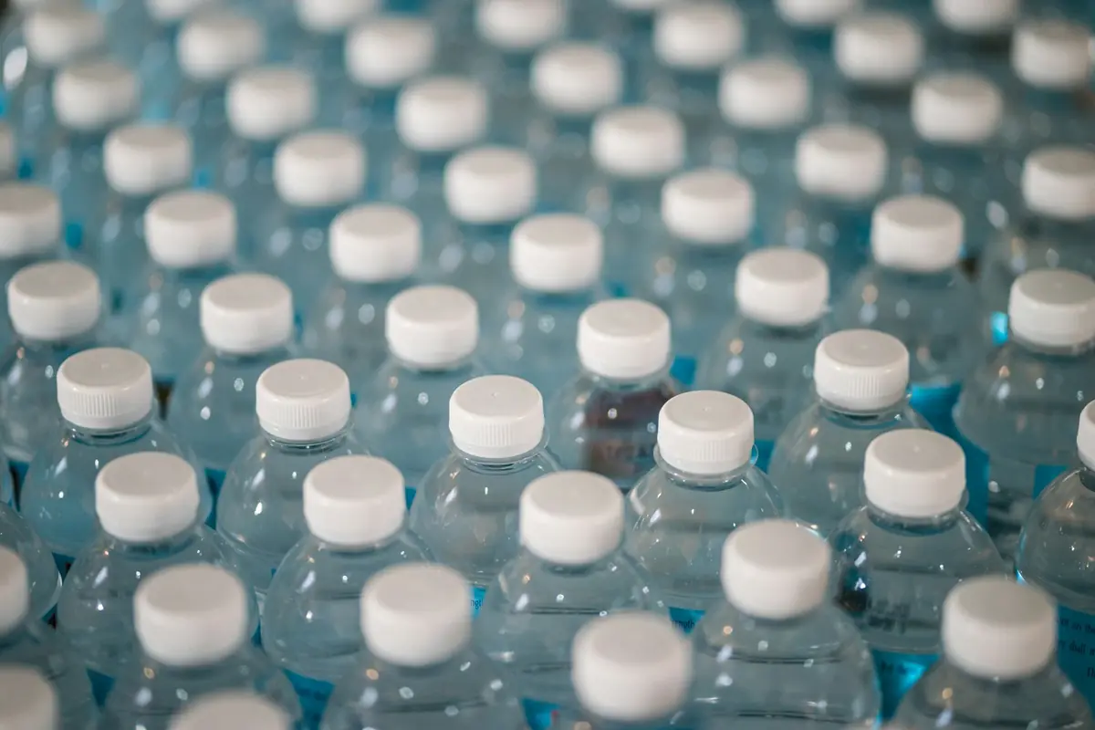 Rows of filled PET water bottles with white caps